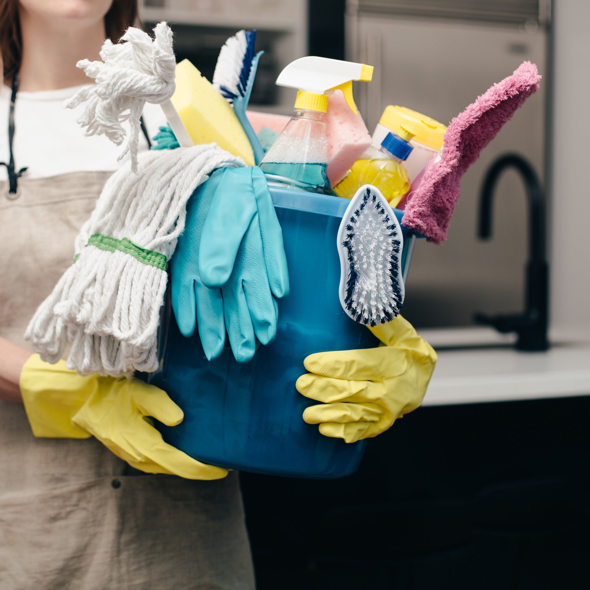 holding bucket of cleaning supplies