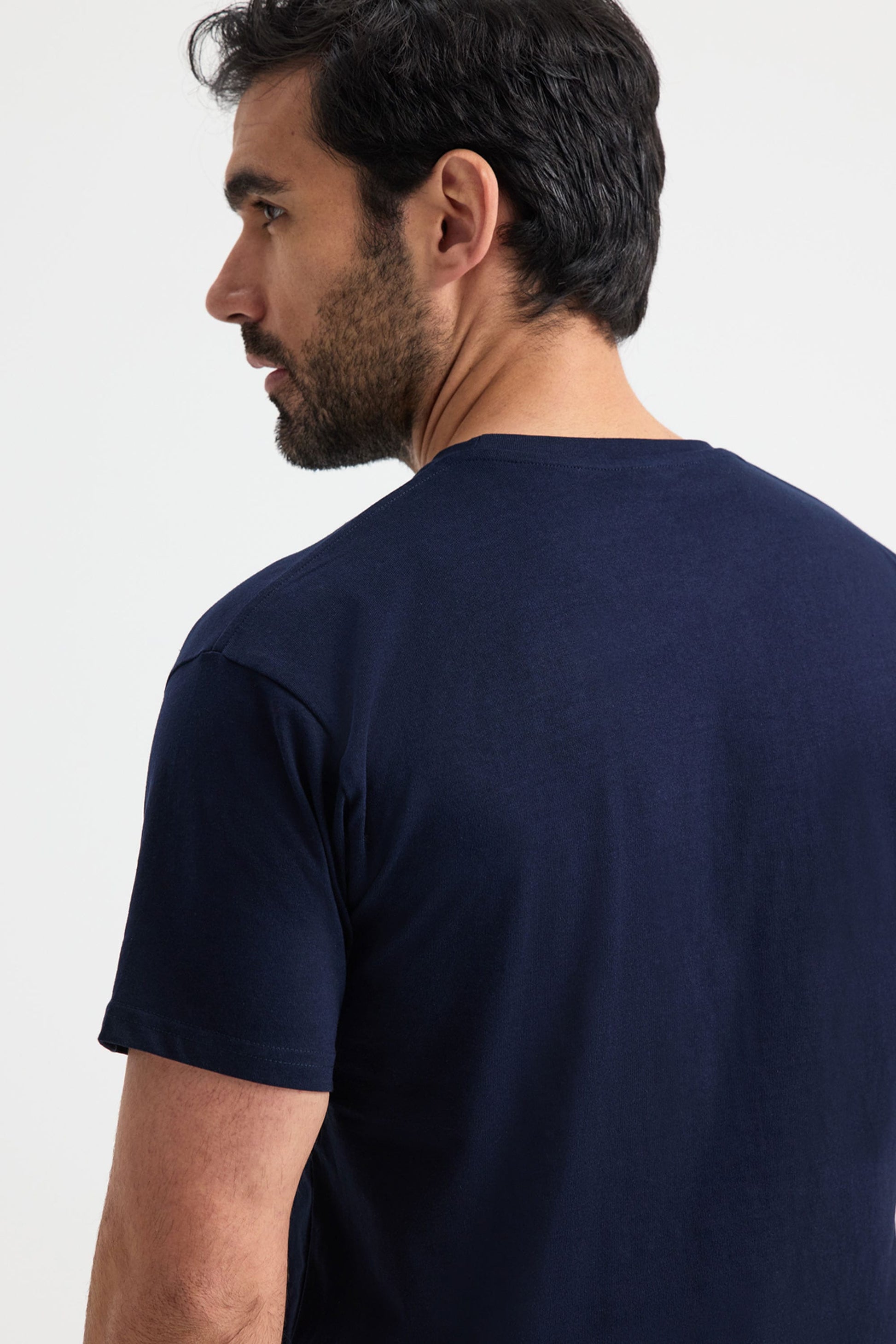 Man wearing a navy t-shirt on a white background