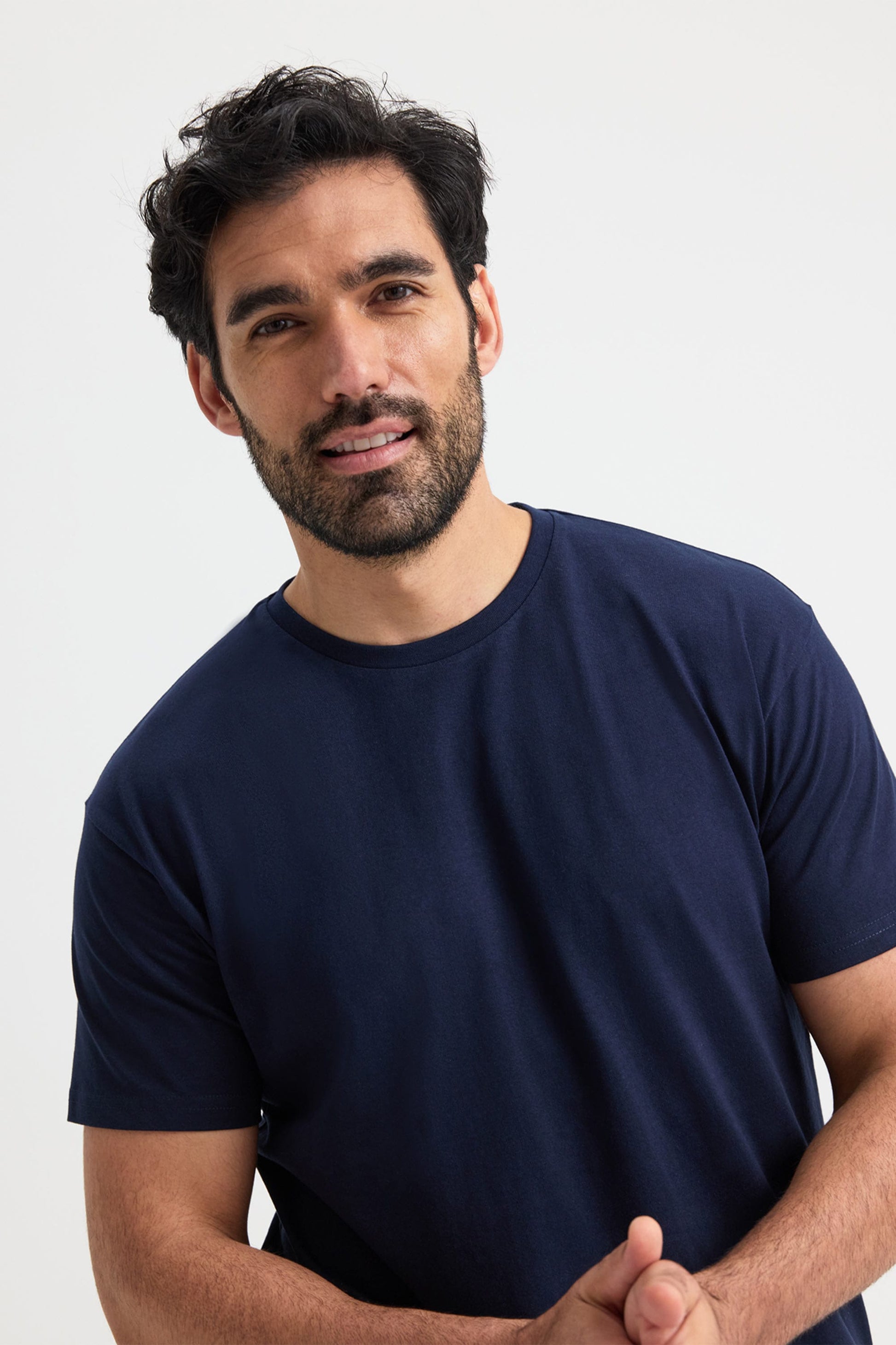 Man wearing a navy blue t-shirt against a white background