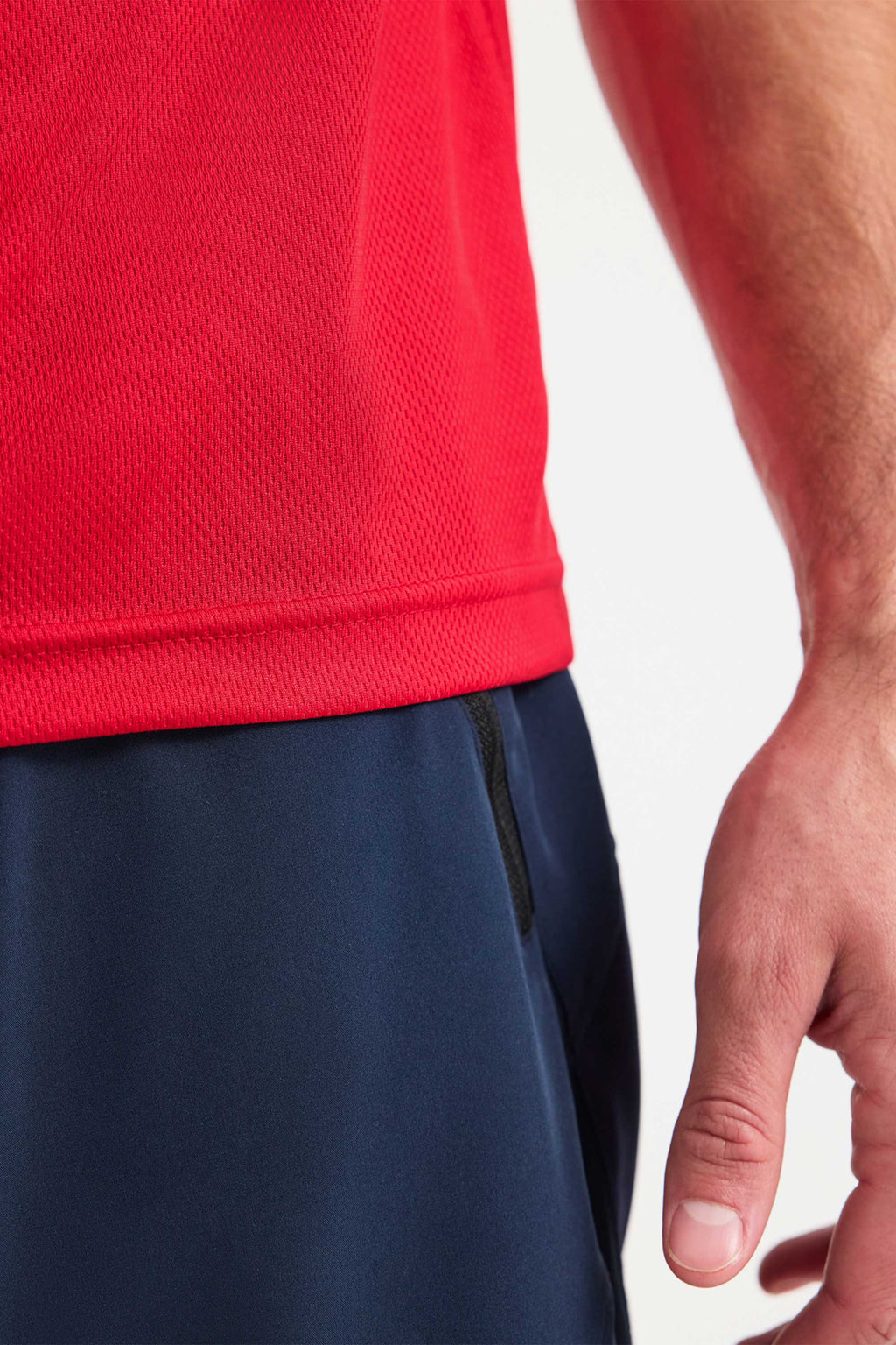 Red athletic shirt and navy shorts on a white background