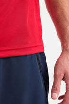 Red athletic shirt and navy shorts on a white background