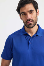 Man wearing a blue polo shirt against a white background