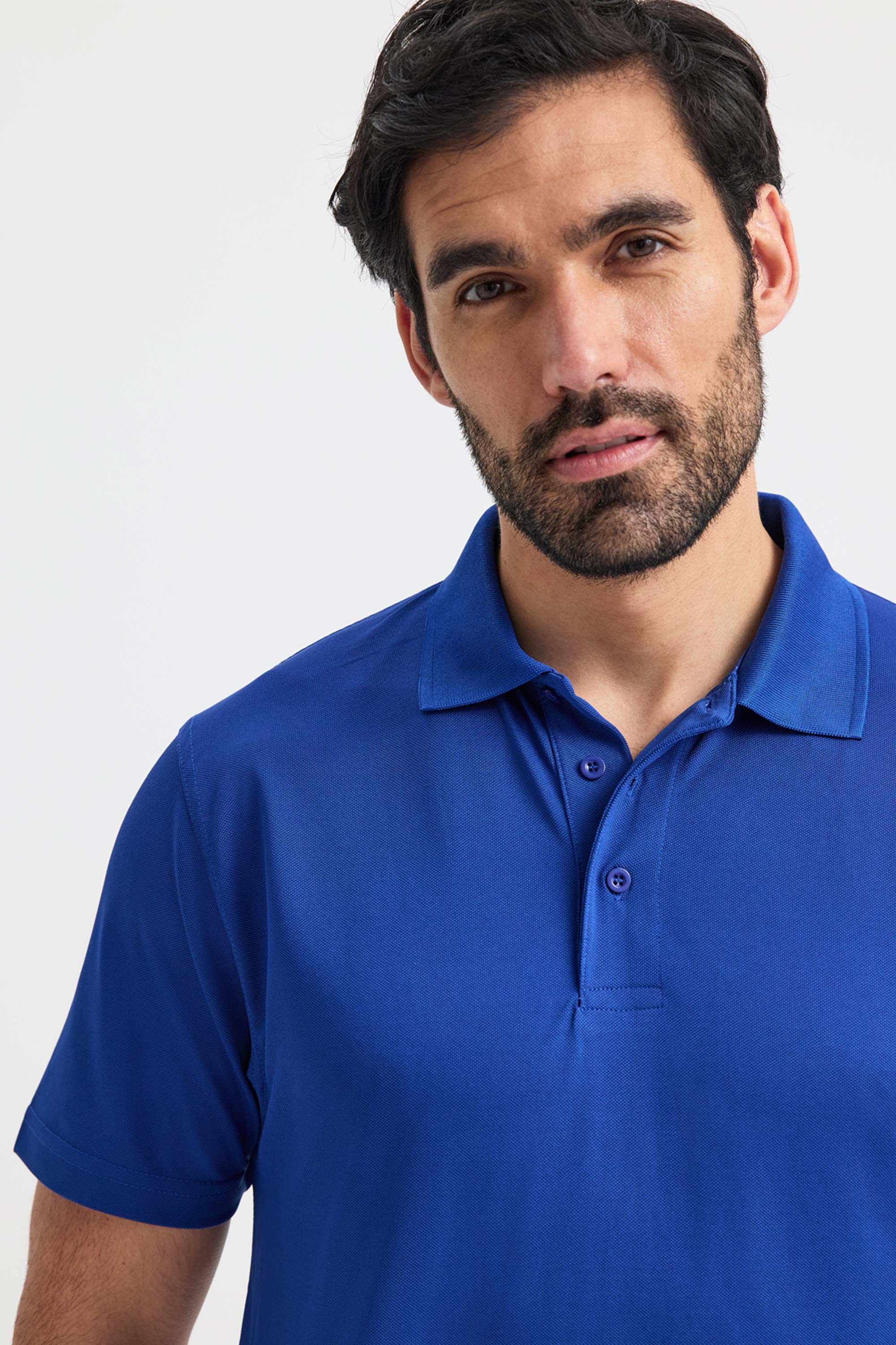 Man wearing a blue polo shirt against a white background